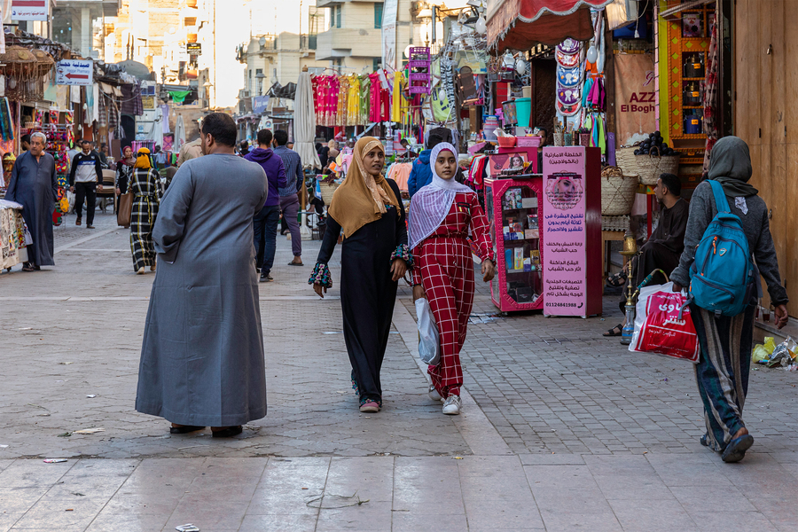 Egyptian women walk through a market