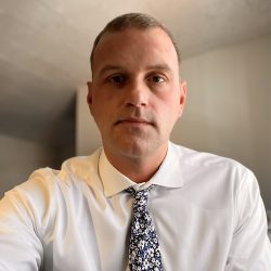 Headshot of Matt Margetta in white shirt and blue floral tie